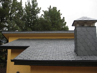Tejado de pizarra con chimenea y remates perimetrales